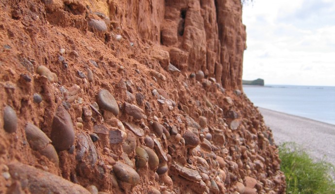 Photo of red cliffs and pebble bed layer above Budleigh Salterton Beach