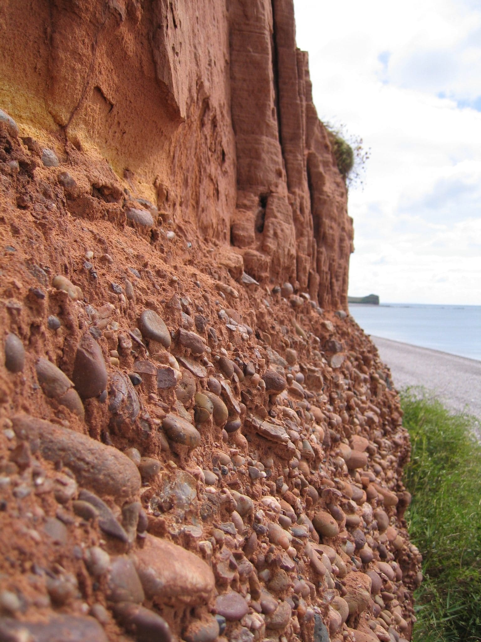 Photo of red cliffs and pebble bed layer above Budleigh Salterton Beach