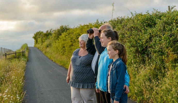 Photo of walkers on the Exe Estuary Trail looking through binoculars