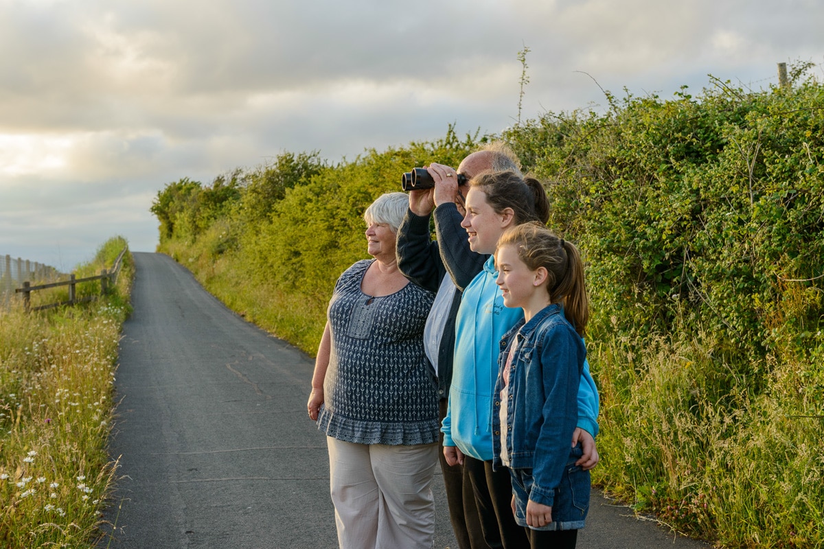 Photo of walkers on the Exe Estuary Trail looking through binoculars