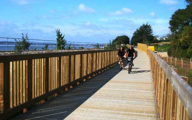 Photo of cyclists crossing a wooden bridge on the Exe Estuary Trail