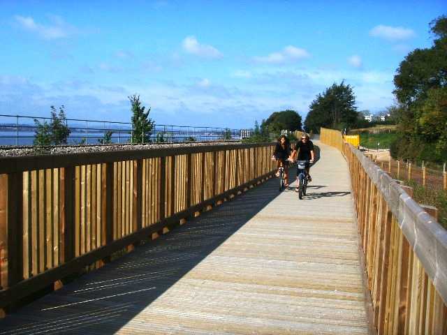 Photo of cyclists crossing a wooden bridge on the Exe Estuary Trail