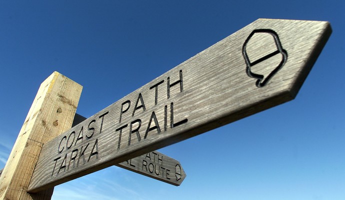 Photo of the top of a waymarking post for the Coast Path and Tarka Trail