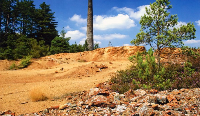 Photo of an arsenic mine tower with waste ground in front