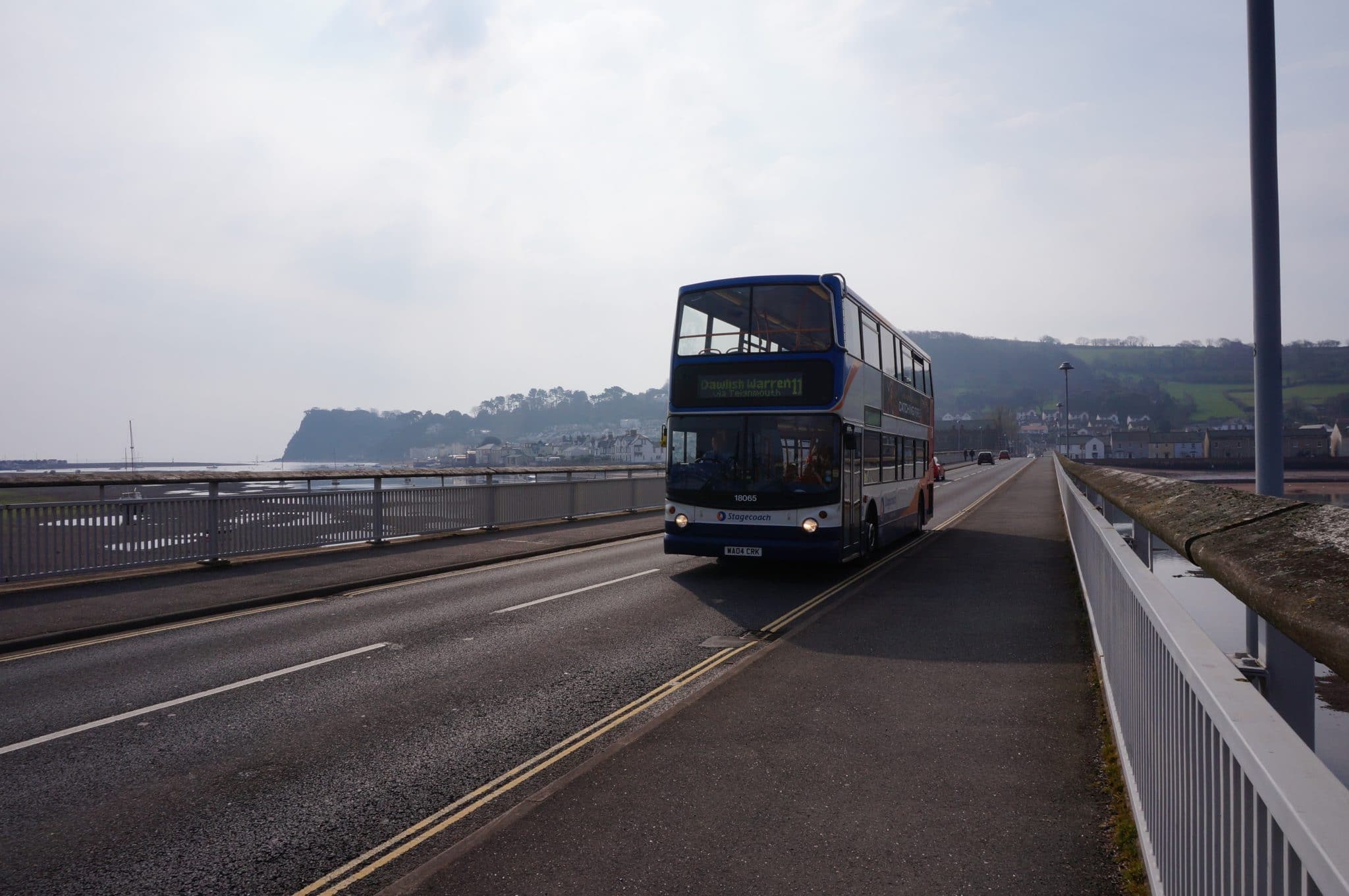 Photo of a double decker bus on the road along the East Devon coast