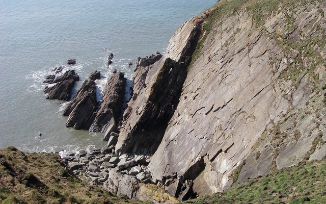 Photo looking down over rocky coastal cliffs towards the sea at Baggy Point