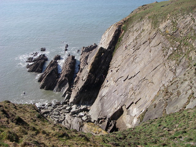 Photo looking down over rocky coastal cliffs towards the sea at Baggy Point