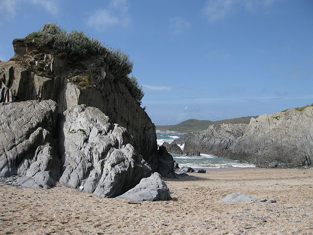 Photo looking across sand and through rocks to the sea at Barricane beach