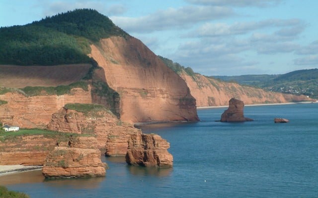 Photo looking across Ladram Bay in East DEvon with red cliffs and sandstone stacks