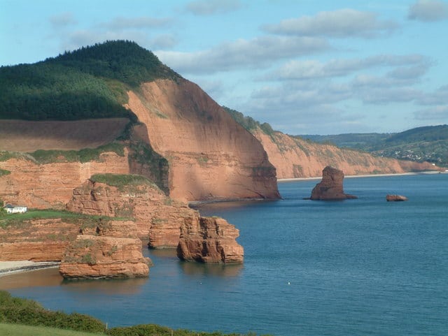 Photo looking across Ladram Bay in East DEvon with red cliffs and sandstone stacks