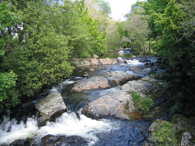 Photo of the River Erme running over rocks with a bridge in the background