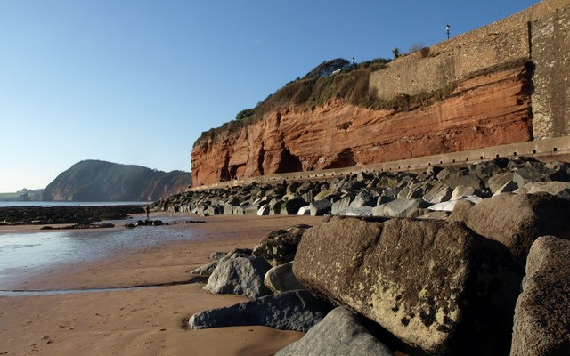 Photo of the red cliffs on Sidmouth seafront with High Peak hill in the background