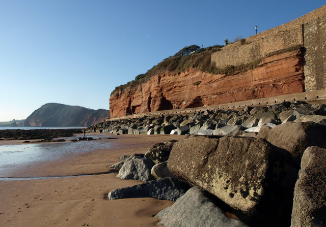 Photo of the red cliffs on Sidmouth seafront with High Peak hill in the background