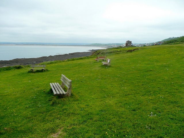 Photo of benches in a green field above the beach at Westward Ho!