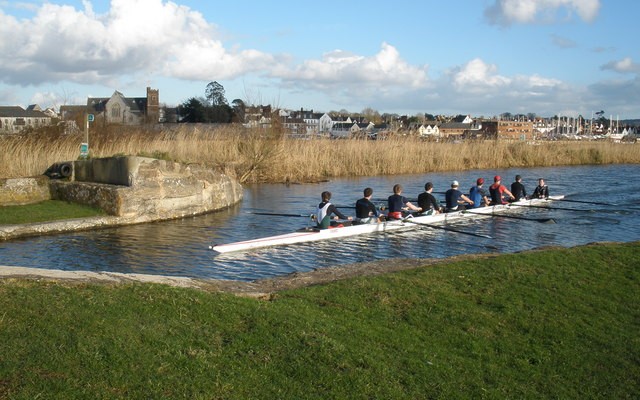 Photo of rowers on the Exeter Ship Canal with views of the city in the background