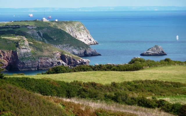 Photo of coastal cliffs at Brixham, with the South Devon coastline in the distance