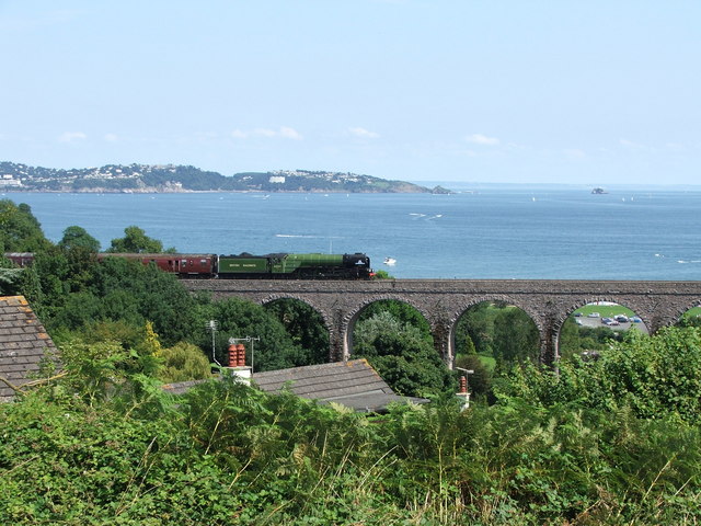 Photo of Broadsands viaduct with a train crossing it and the sea and coastline in the background