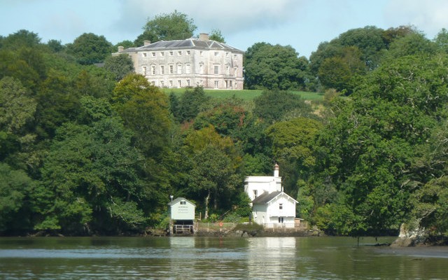 Photo looking across the river Dart to the boathouse at Sharpham House with the main house on the hill behind