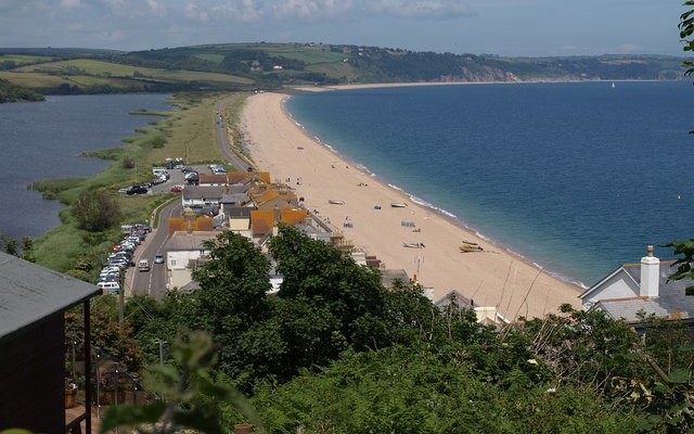 Landscape photo looking along the length of the beach and road at Slapton Ley with lagoon on the left and sea on the right